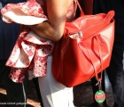 Un'elegante proprietaria in Tribuna con giacca a fiori in bianco e rosso per la giornata del GP di Milano e borsa coordinata