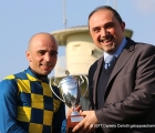 A sinistra il fantino Dario Vargiu premiato dal Dr. Procino della Trenno, per la vittoria di Voice Of Love nel GP Ambrosiano (G3)
