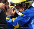 Il fantino Federico Bossa al dissellaggio del vincitore del Premio Lombardia con la giubba della Sc. Genets S.R.L. proprietaria di Pentagono